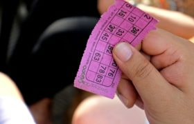 Hand die een roze bingokaart vasthoudt