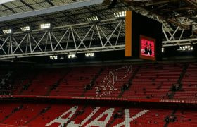 Vrijwel leeg Ajax stadion, het Ajax logo is te zien op de rode tribune