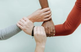 Vier Mensen die Elkaars arm Vasthouden