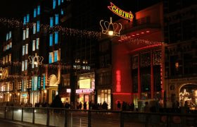 Straat in Amsterdam in de avond, inclusief kerstverlichting en neon letters met het woord casino.
