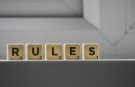 Scrabbelstenen met de tekst “rules”
