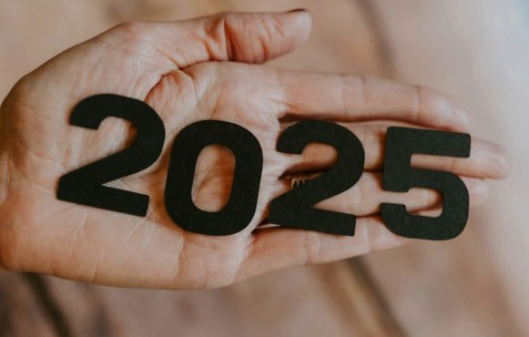 Handpalm met daarop de zwarte cijfers 2025