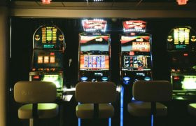 Vier verlichte gokkasten met lege stoelen