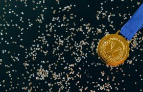 Gouden medaille tegen een zwarte achtergrond met glitter