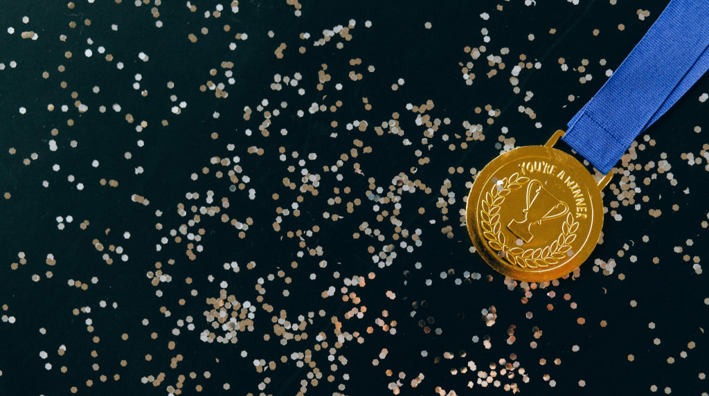Gouden medaille tegen een zwarte achtergrond met glitter