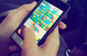Handen die een smartphone vasthouden en een mobiele game spelen