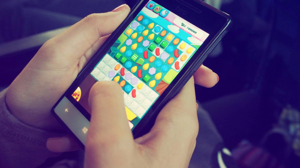 Handen die een smartphone vasthouden en een mobiele game spelen