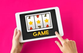 Vrouwenhanden met tablet waarop een online gokkast te zien is