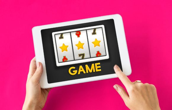 Vrouwenhanden met tablet waarop een online gokkast te zien is