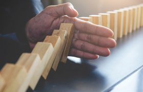 Hand die blanco houten dominostenen tegenhoudt