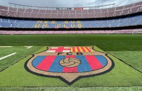 Leeg voetbalstadion met in het gras het logo van FC Barcelona
