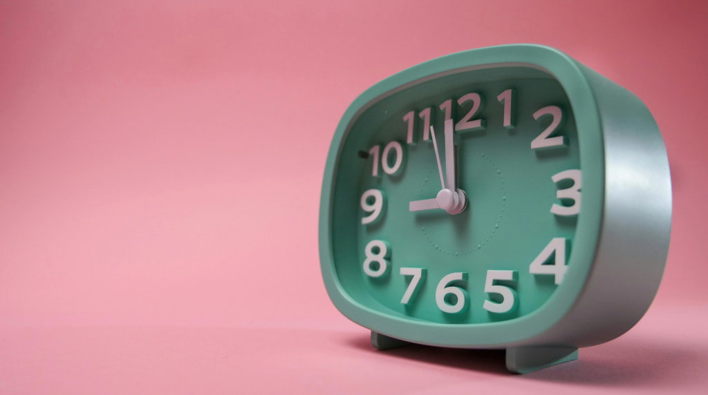 Mintgroene retro klok (wekker) op een roze achtergrond