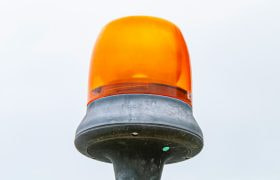 Een oranje alarmlicht op een blanco achtergrond