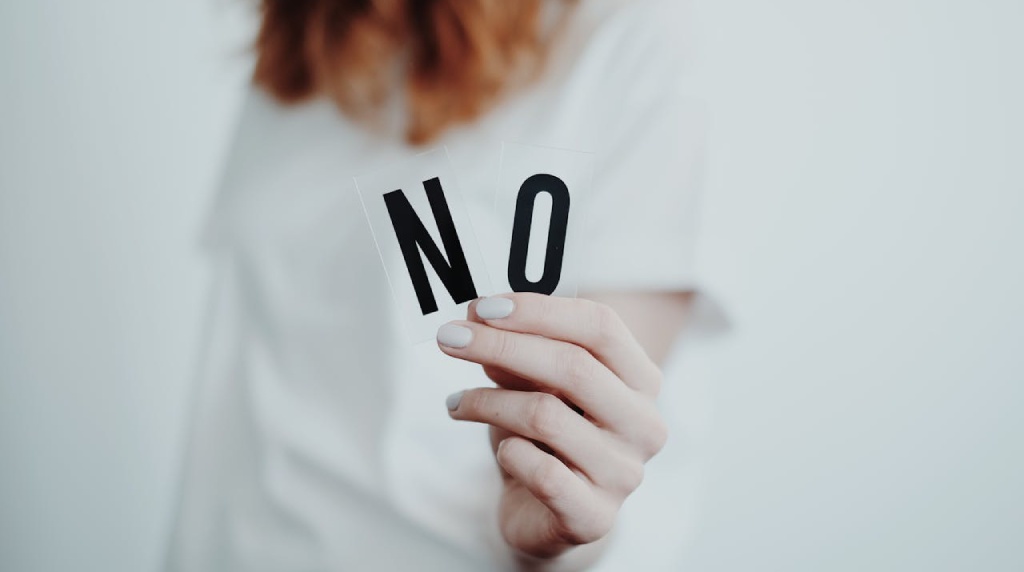 Vrouwenhand die de letters “N O” vasthoudt