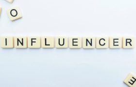 Scrabblestenen die het woord “influencer” spellen