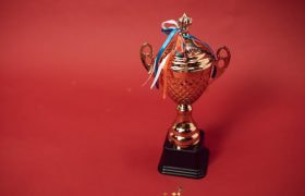 Bronzen beker met strik (Nederlandse vlag) op een rode achtergrond