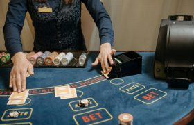 Blauwe speeltafel met fiches en dealer die kaarten deelt