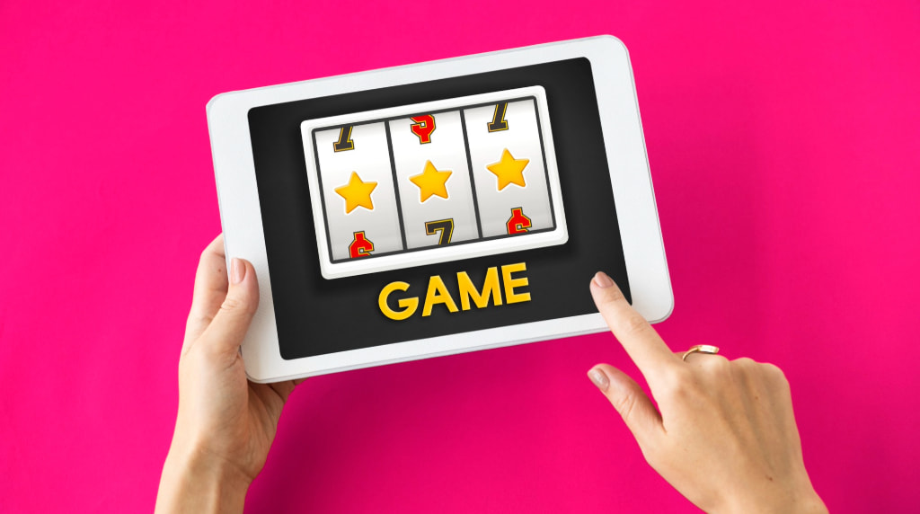 Vrouwenhanden met tablet, daarop staat een slot met het woordje “game”