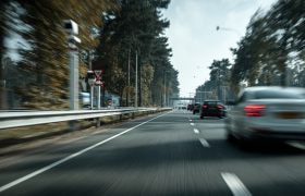 Еen flitspaal aan de zijkant van een drukke Nederlandse snelweg