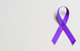 Paars lint als symbool tegen kanker, witte achtergrond