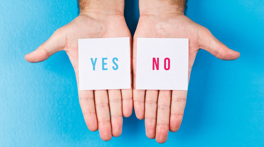 Twee handen met ieder een briefje, op de ene staat Yes en op de andere No