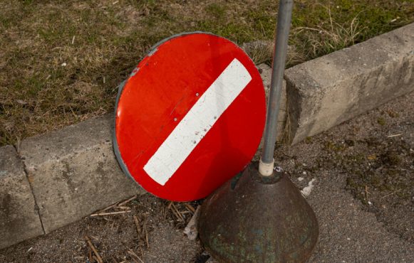 Verkeersbord verboden, waarvan het bord zelf is afgebroken en op de weg ligt