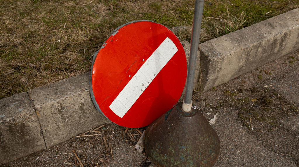 Verkeersbord verboden, waarvan het bord zelf is afgebroken en op de weg ligt