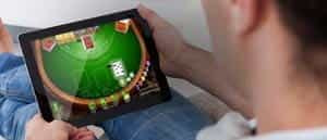 A man playing at an online casino on a tablet.