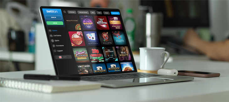 A laptop on a desk displaying a selection of games available at Betiton casino.