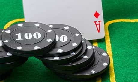 one card faceup on a playing table with a stack of casino chips next to it
