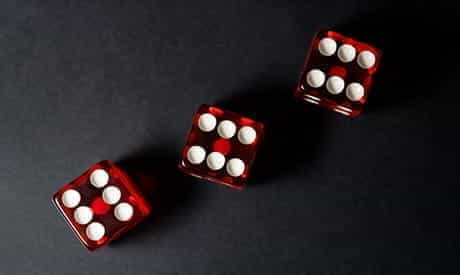 Three red dice on a black table