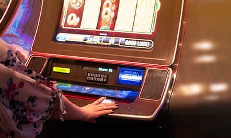 A person playing on a slot machine.