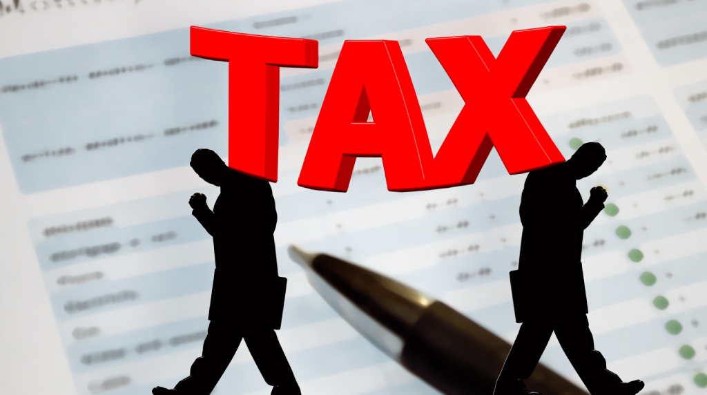 Ilustrație cu cuvântul TAX peste un document financiar