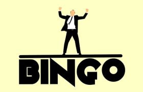 Un bărbat în costum negru care stă pe un text Bingo