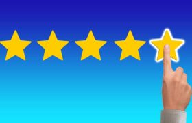 5 stele aurii pe fon albastru și un deget care arată evaluarea maximă.