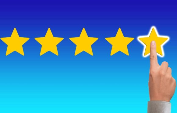 5 stele aurii pe fon albastru și un deget care arată evaluarea maximă.