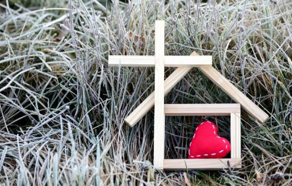 Bețe de lemn reprezentând o casă și o cruce, cu inimă roșie în interior.