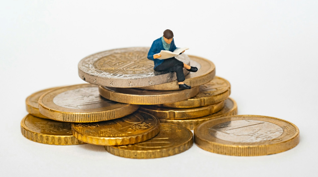 O figurină în miniatură așezată pe niște monede