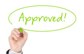 Mână care scrie cu marker verde cuvântul Approved