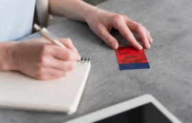 Cineva notează într-o agendă date de pe un card