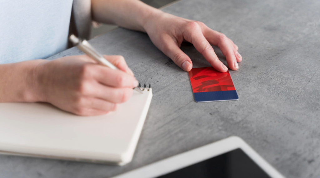 Cineva notează într-o agendă date de pe un card