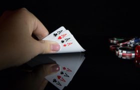 Mână de cărți de cazino și jetoane pe masă