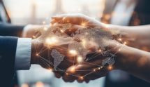 Două persoane strâng mâna, peste imagine fiind suprapusă o hartă digitală a lumii