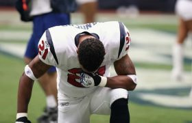 American football player drops to his knees during a game.