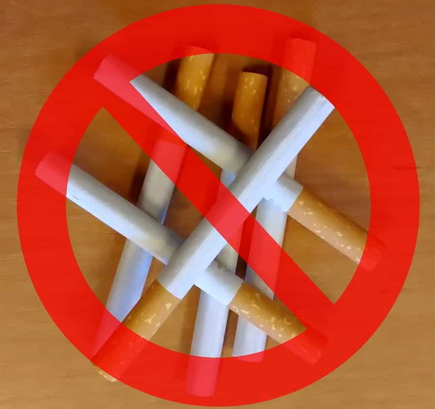 A pile of cigarettes on a table, overlaid with a red, crossed circle.