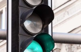 A traffic light in the street showing a green light.
