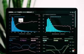 A laptop device displaying an interface showing various statistics and graphs related to the revenue performance of a specific entity.