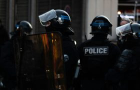Police in riot gear protecting a public space