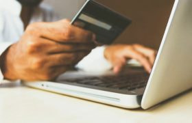 Person entering their credit card data into a computer