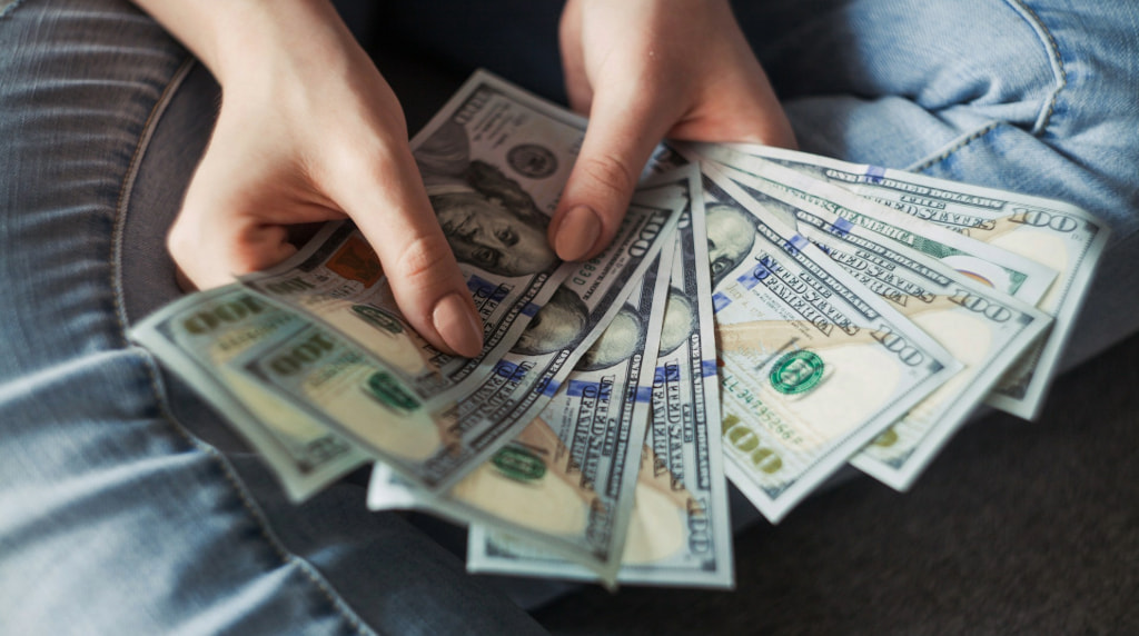 Crisp US hundred dollar bills fanned out